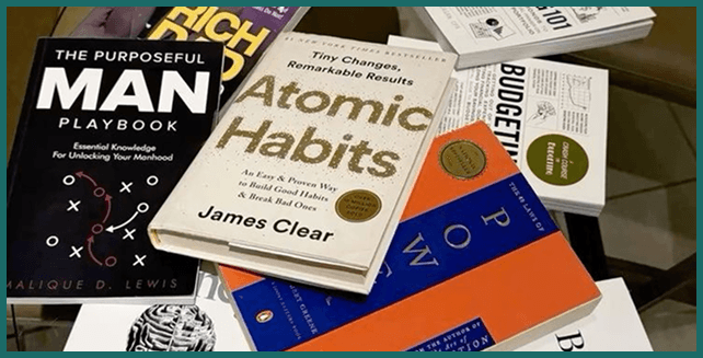 Collection of published books including Atomic Habits and The Purposeful Man Playbook